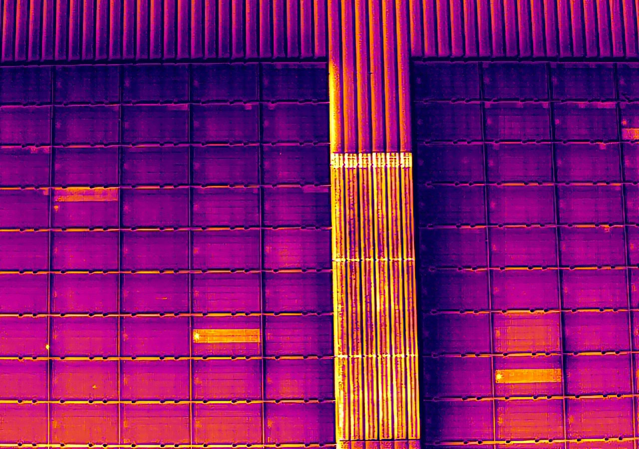 Magenta bis Orangefarbiges Wärmebild eines grösseren Modulfeldes mit hellen Flecken